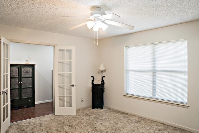 interior space featuring carpet, ceiling fan, a textured ceiling, and french doors