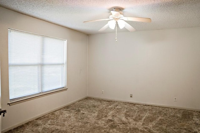 carpeted empty room featuring a ceiling fan and a textured ceiling