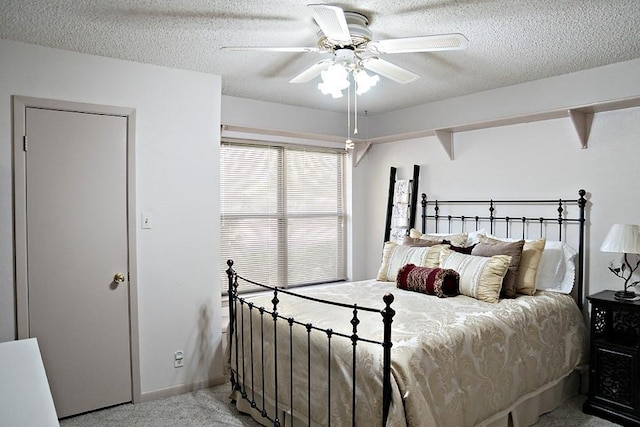 carpeted bedroom with a ceiling fan and a textured ceiling