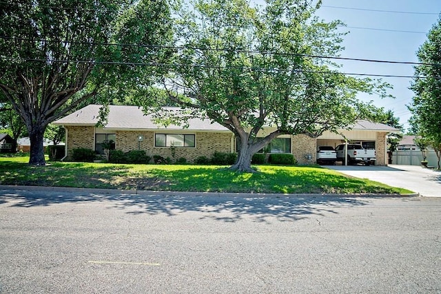 ranch-style house featuring a garage, concrete driveway, fence, a front yard, and brick siding