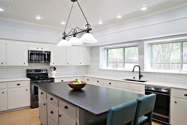 kitchen with decorative backsplash, appliances with stainless steel finishes, light wood-style floors, white cabinetry, and a sink