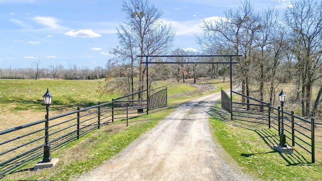 exterior space with driveway, a yard, a rural view, and fence