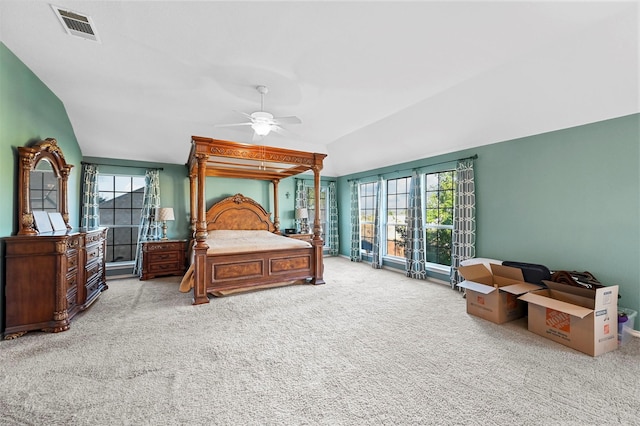 carpeted bedroom featuring visible vents, vaulted ceiling, and a ceiling fan