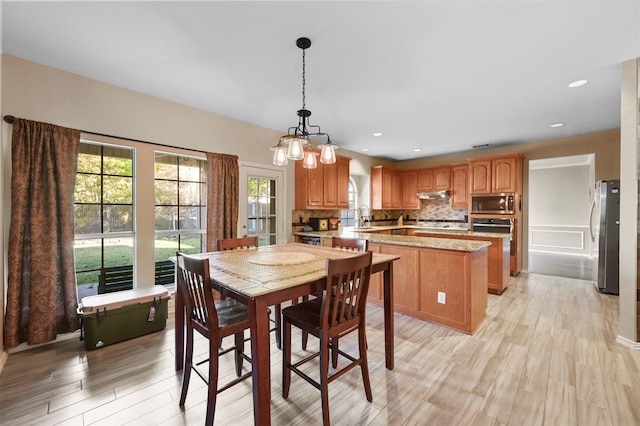 dining area featuring light wood-style flooring and recessed lighting