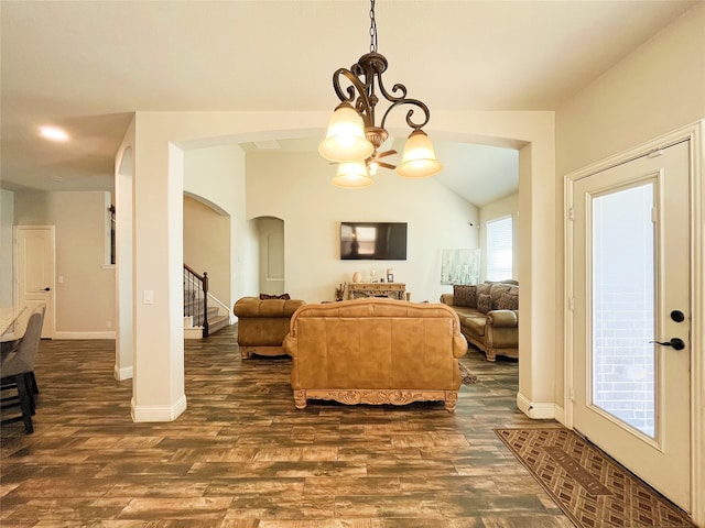 living area featuring stairs, baseboards, dark wood finished floors, and a notable chandelier