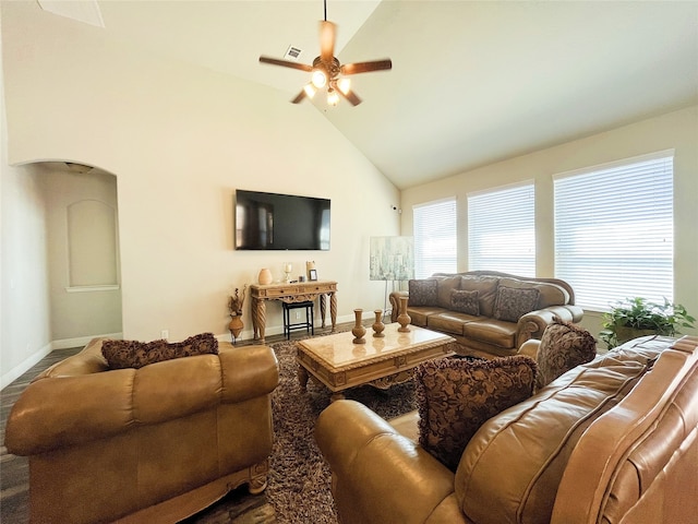 living area with high vaulted ceiling, baseboards, arched walkways, and a ceiling fan