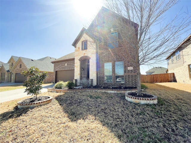 view of front of house featuring brick siding, concrete driveway, fence, a garage, and stone siding