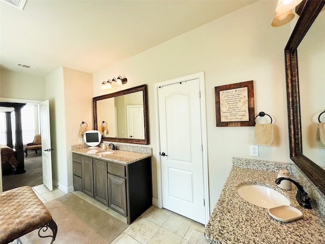 bathroom featuring tile patterned flooring, visible vents, two vanities, and a sink