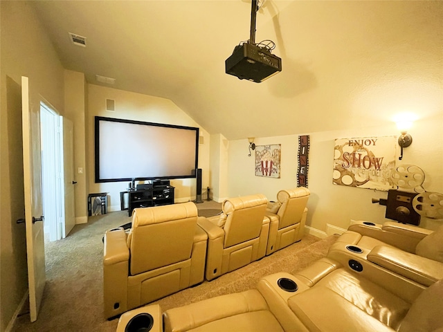 carpeted cinema with lofted ceiling, visible vents, and baseboards