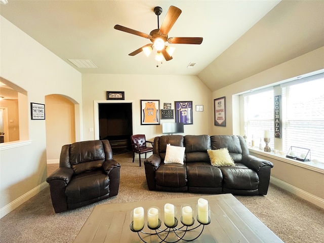 living room with carpet floors, lofted ceiling, arched walkways, and baseboards