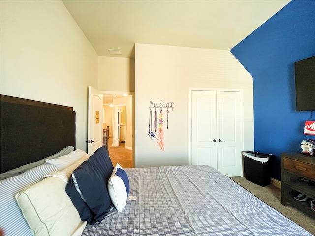 carpeted bedroom featuring a closet and vaulted ceiling