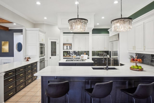 kitchen with a chandelier, built in appliances, light tile patterned floors, a peninsula, and white cabinetry