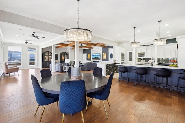 dining area with a healthy amount of sunlight, crown molding, and wood finished floors