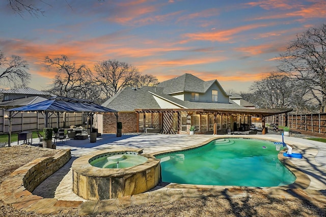 view of swimming pool with a patio, a fenced backyard, and a pool with connected hot tub