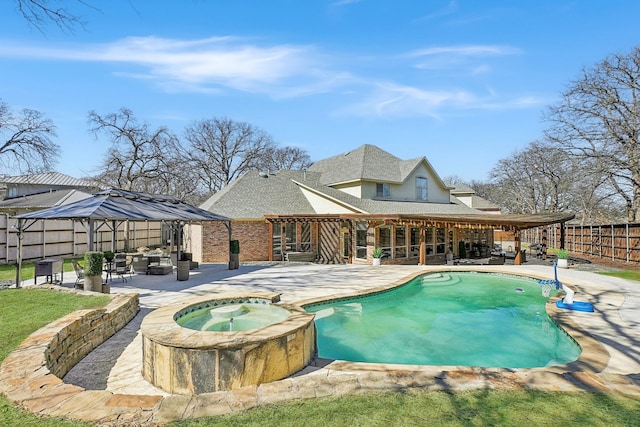 view of swimming pool featuring a patio, a fenced backyard, and a pool with connected hot tub