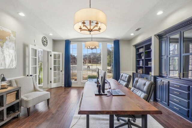 office featuring dark wood finished floors, an inviting chandelier, built in features, and visible vents