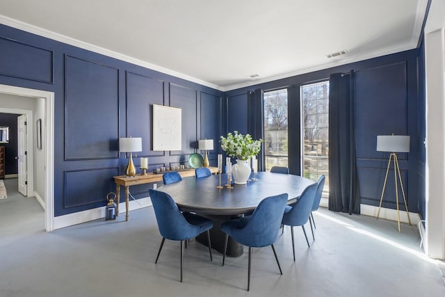 dining room featuring a decorative wall, finished concrete floors, visible vents, and ornamental molding