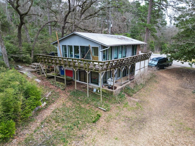 view of front of home featuring dirt driveway and a wooden deck