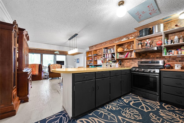 kitchen featuring gas range, a peninsula, light countertops, under cabinet range hood, and open shelves