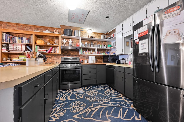 kitchen featuring black dishwasher, open shelves, stainless steel range with gas stovetop, and freestanding refrigerator