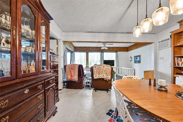 dining area featuring a textured ceiling, ceiling fan, light wood-style flooring, a wall mounted air conditioner, and crown molding