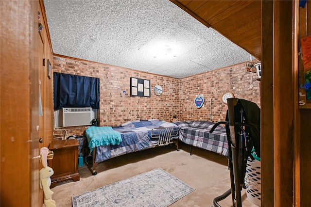 carpeted bedroom with cooling unit, a textured ceiling, and brick wall