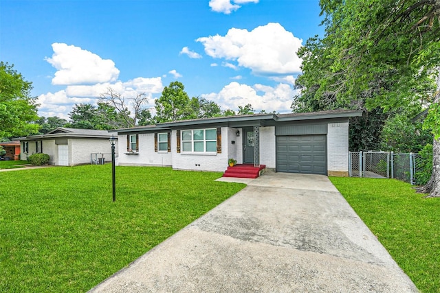 view of front of home with driveway, fence, a front yard, an attached garage, and brick siding