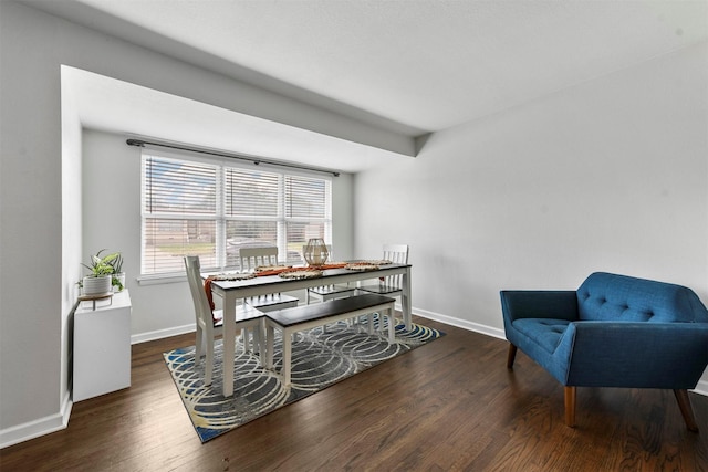 dining space with baseboards and wood finished floors