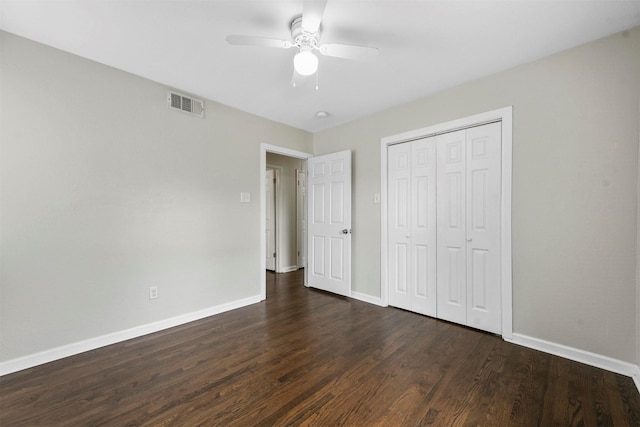 unfurnished bedroom with visible vents, baseboards, a closet, and dark wood-style floors