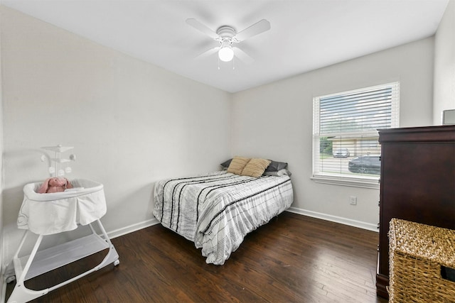 bedroom with ceiling fan, baseboards, and wood finished floors