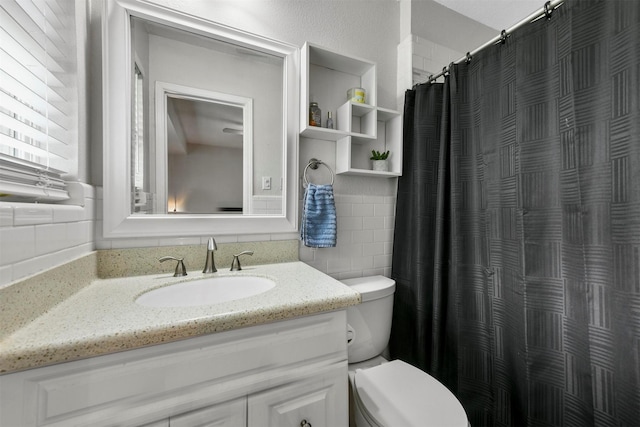 bathroom featuring toilet, tile walls, and vanity