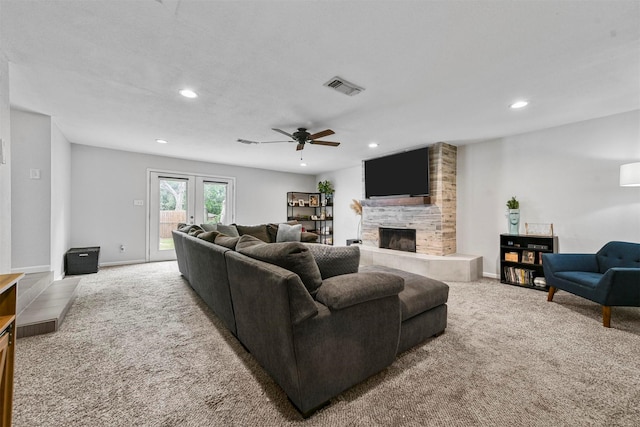 living area featuring carpet, baseboards, visible vents, recessed lighting, and a tile fireplace