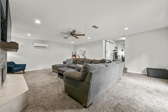 living area featuring a wall mounted air conditioner, visible vents, recessed lighting, a barn door, and carpet floors