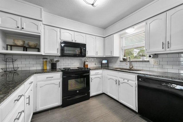 kitchen featuring white cabinetry, black appliances, backsplash, and a sink