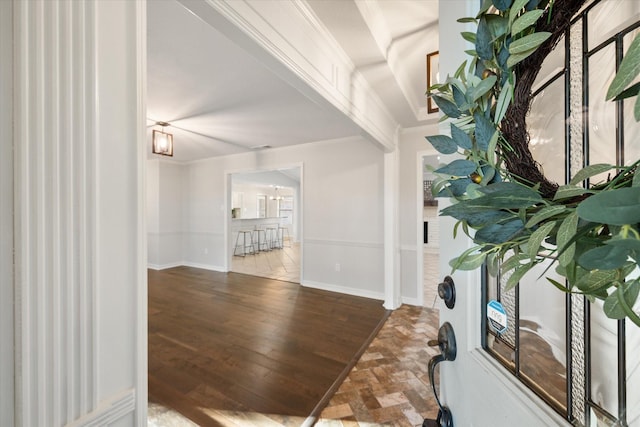 interior space with ornamental molding and wood finished floors