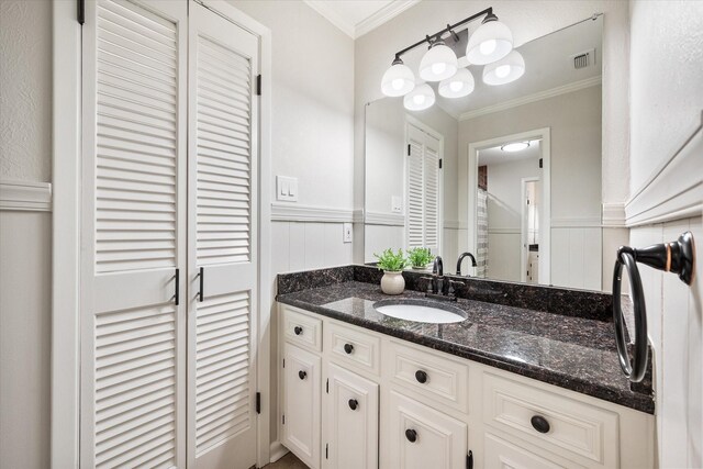 2013 Glenwood Cir, Corsicana, TX 75110 - bathroom featuring vanity, wainscoting, ornamental molding, and a closet