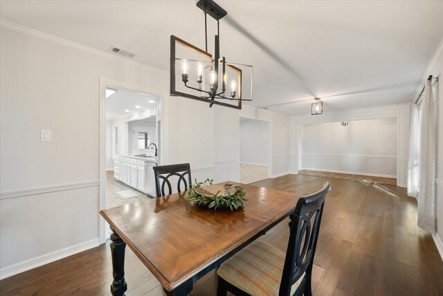 2013 Glenwood Cir, Corsicana, TX 75110 - dining space featuring a chandelier, wood finished floors, ornamental molding, and baseboards