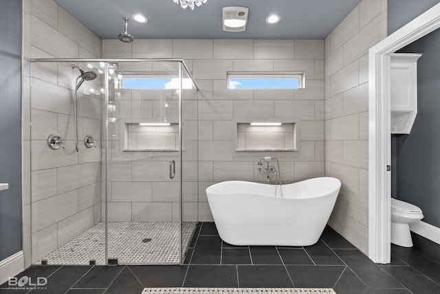 full bathroom featuring a shower stall, a freestanding bath, toilet, recessed lighting, and tile patterned floors