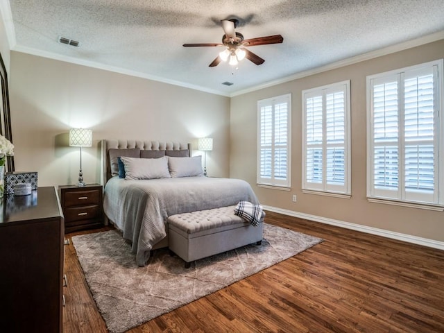 bedroom with dark wood-type flooring, visible vents, and crown molding