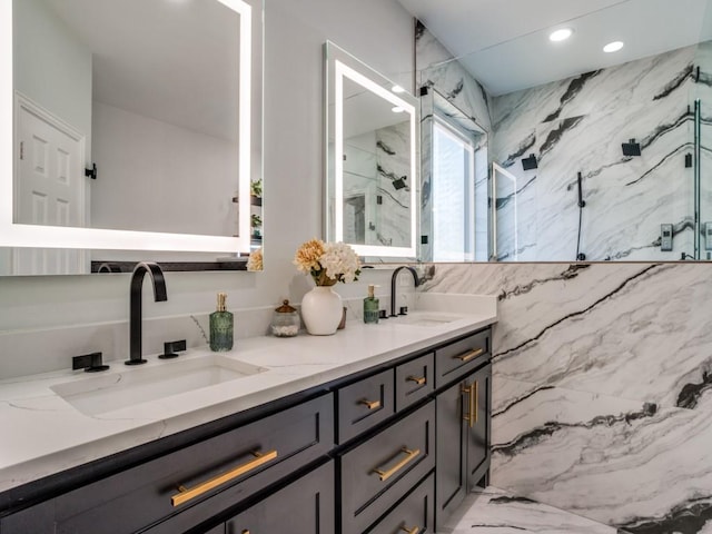 full bathroom featuring double vanity, a marble finish shower, a sink, and recessed lighting