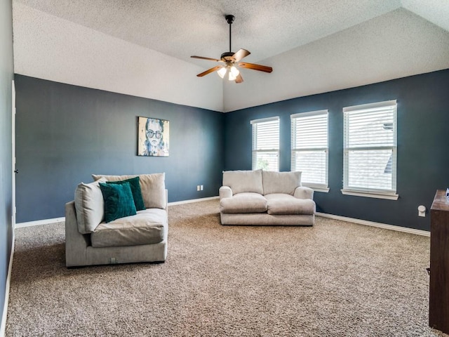 living room featuring baseboards, lofted ceiling, ceiling fan, a textured ceiling, and carpet floors