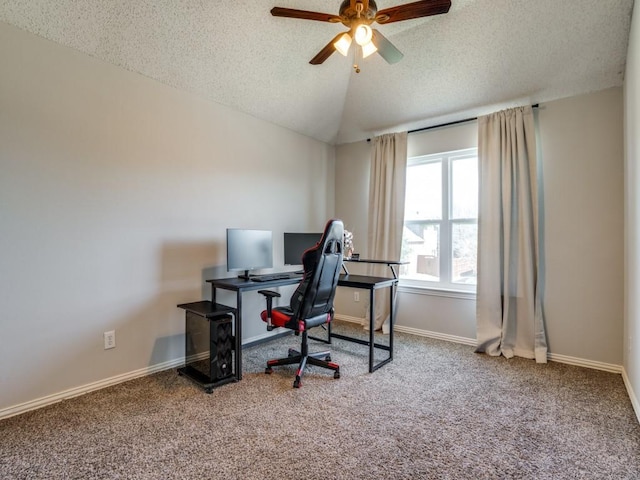 home office with baseboards, ceiling fan, vaulted ceiling, a textured ceiling, and carpet flooring