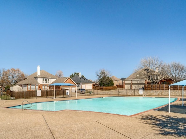 pool with fence and a patio