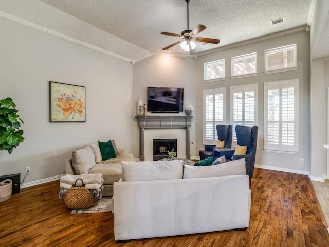 living room featuring visible vents, a fireplace, ornamental molding, and wood finished floors