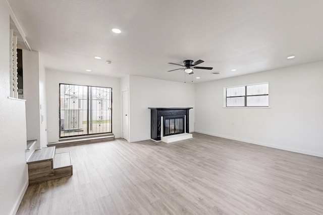 unfurnished living room with recessed lighting, baseboards, a multi sided fireplace, and wood finished floors