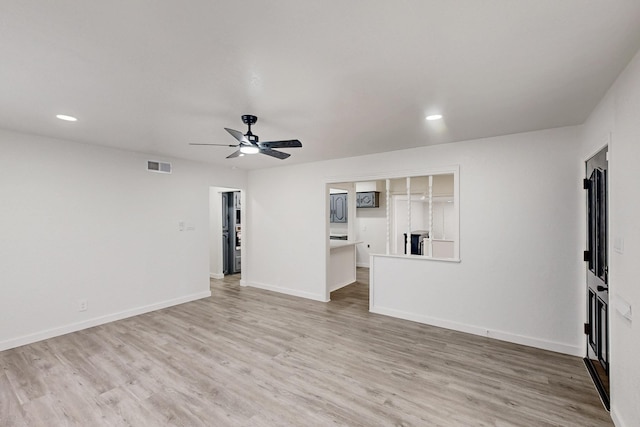 unfurnished living room featuring light wood finished floors, baseboards, visible vents, and ceiling fan