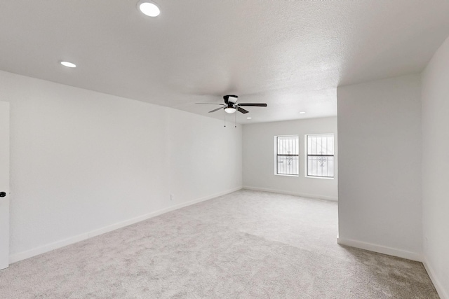 spare room featuring ceiling fan, a textured ceiling, recessed lighting, light colored carpet, and baseboards