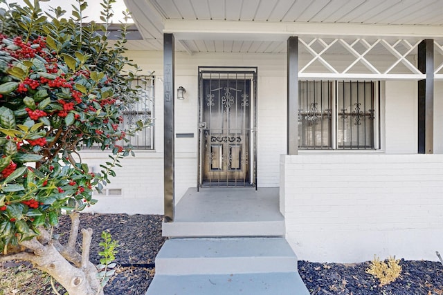 entrance to property featuring brick siding and crawl space