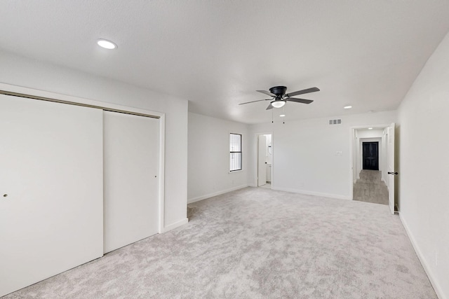 unfurnished bedroom with visible vents, light colored carpet, ceiling fan, a closet, and recessed lighting