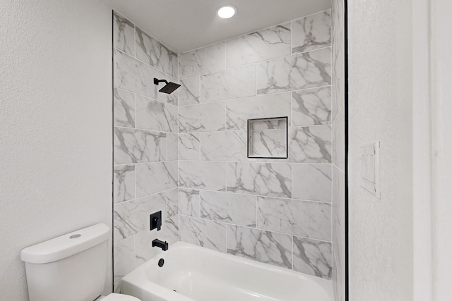 full bathroom featuring a textured wall, shower / bath combination, and toilet